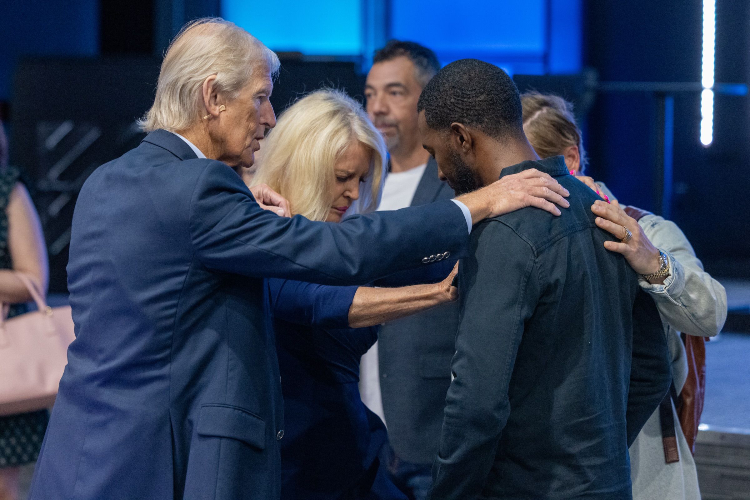 Apostle Theo and Dr Bev Wolmarans laying hands on a man in prayer