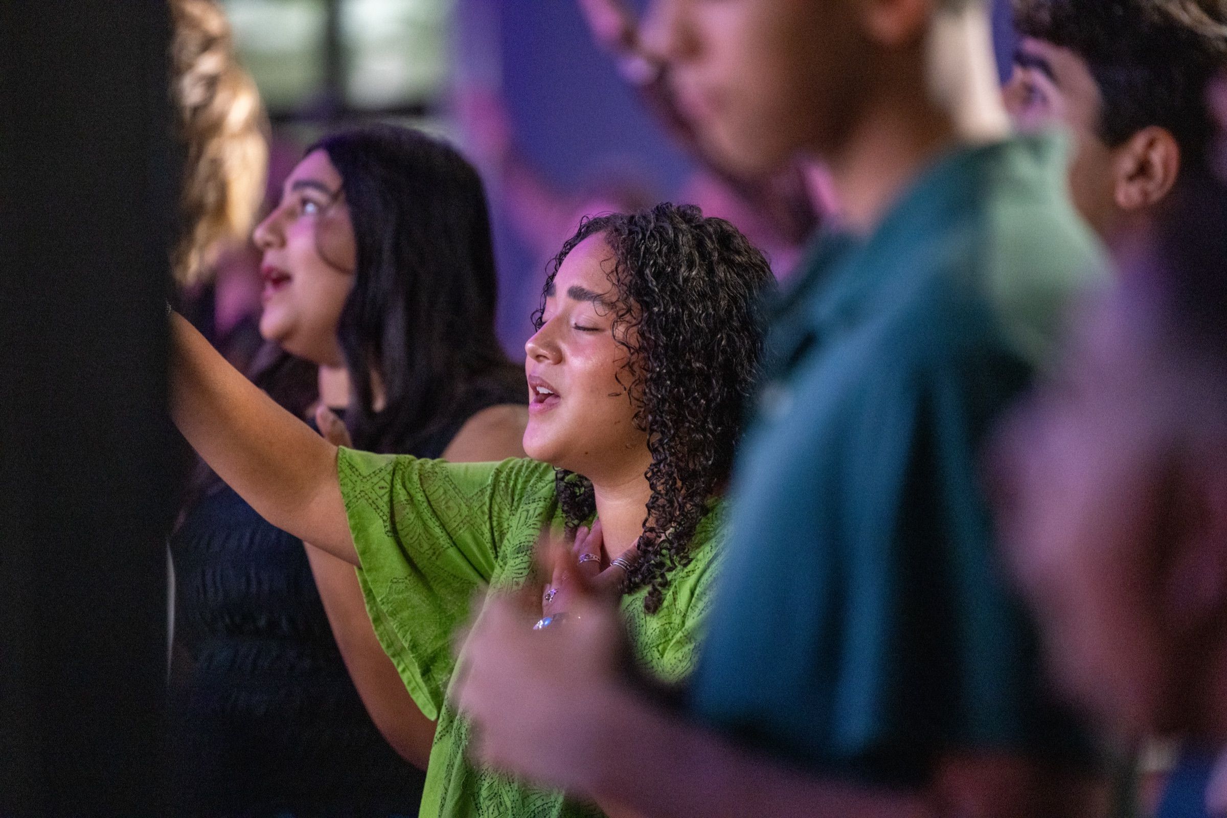 A young woman worshipping with her hand raised